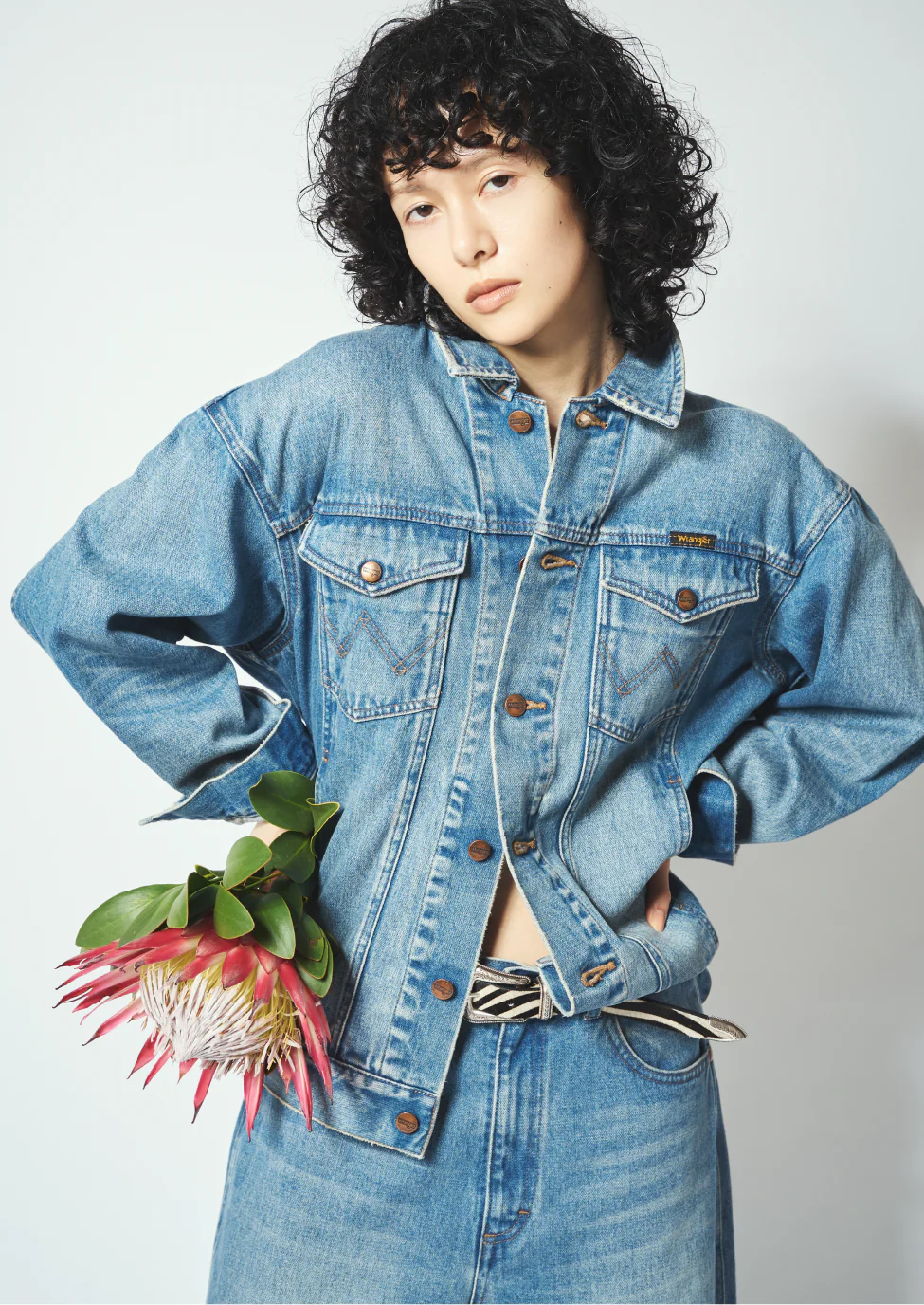 Whim Gazette × Wrangler ブルーのデニムジャケットとデニムパンツ、ゼブラ柄ベルトのセットアップコーディネート