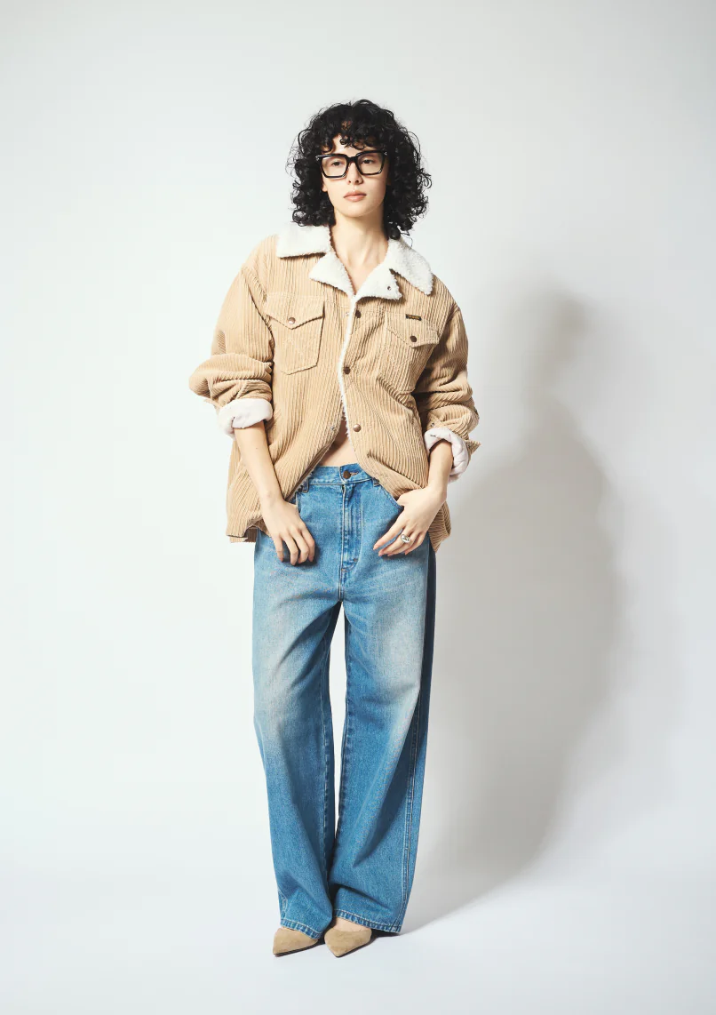 Whim Gazette × Wrangler ベージュのコーデュロイブルゾンにデニムパンツと眼鏡を合わせたコーディネート