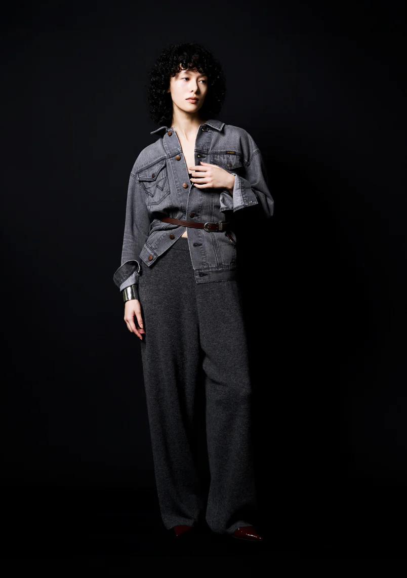 Whim Gazette × Wrangler ブラックデニムジャケットにグレーのニットパンツとナローベルトを合わせたコーディネート